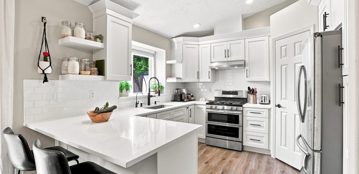 White quartz countertops templated and fitted over white shaker cabinets