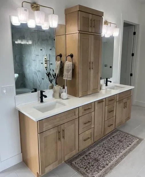 Wood bathroom vanity with dual sinks, white quartz countertop, and matching storage tower cabinet