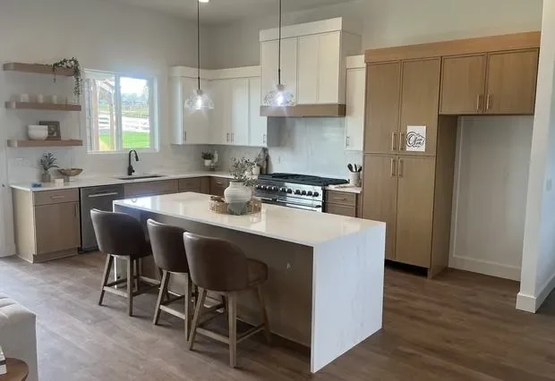 White and natural wood kitchen cabinets with white quartz island and bar seating